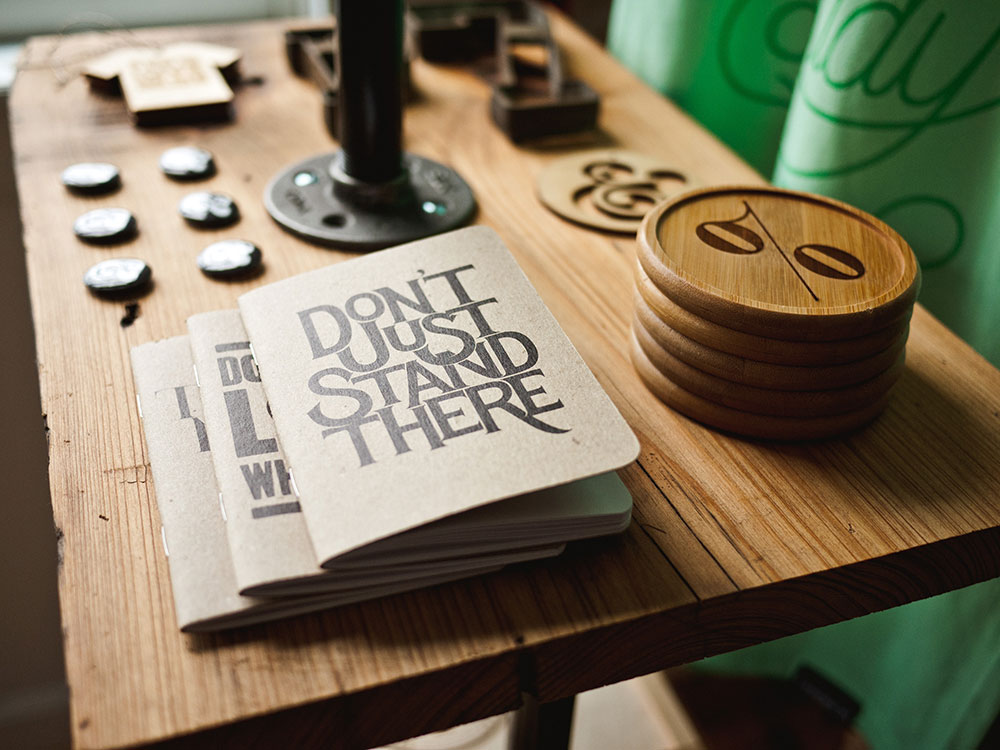 Books, buttons and coaster for sale on wooden table