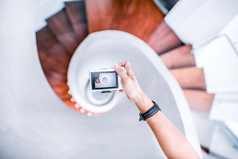 Person taking a photo of a spiral staricase